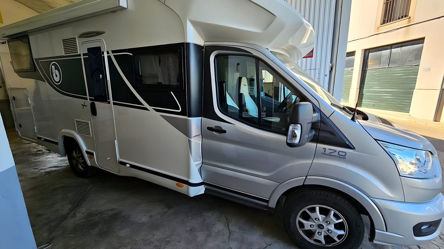 Autocaravana comercial de serie aparcada junto al taller