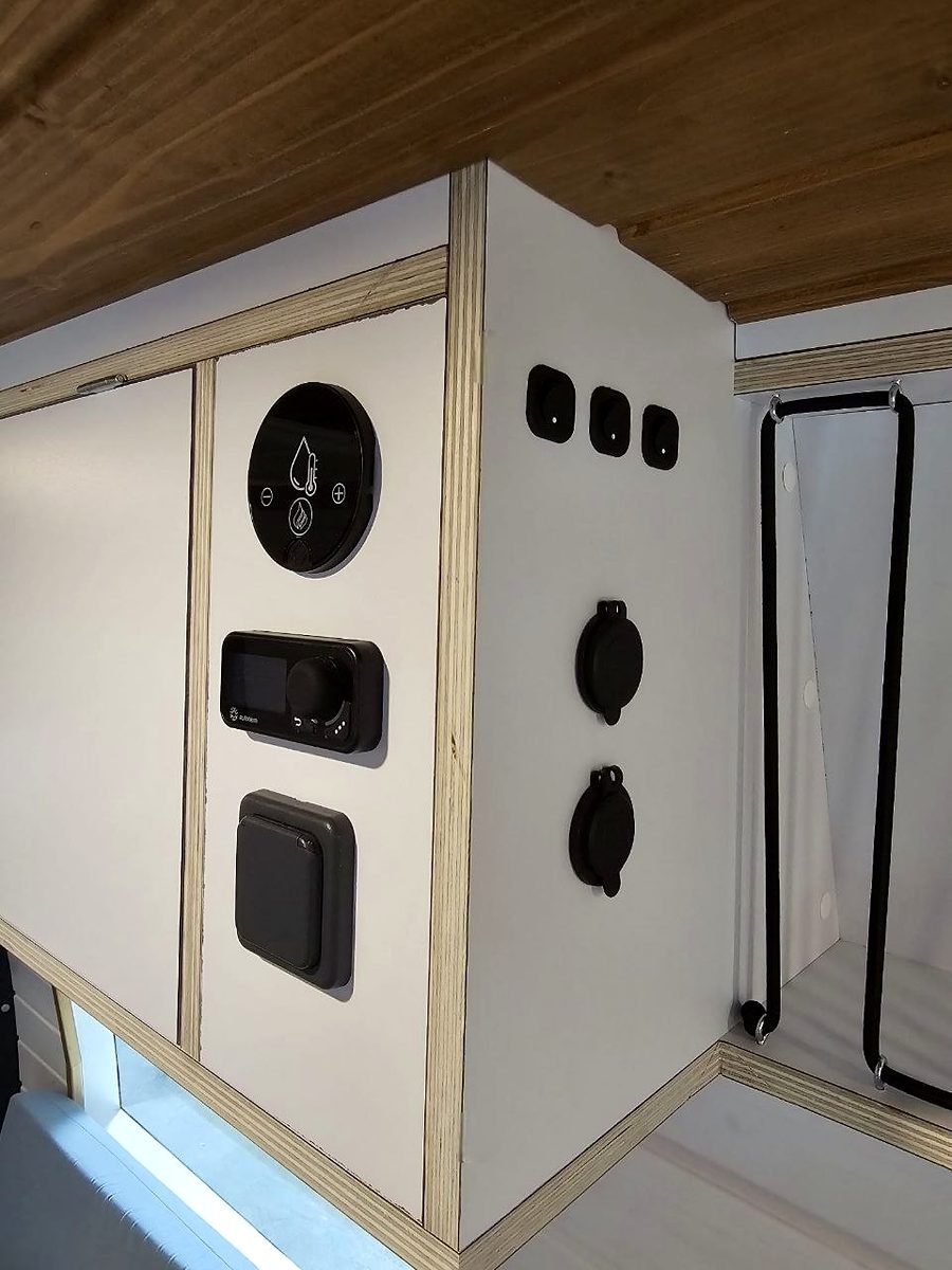 Cuadro de mandos de una camper con interruptores y tomas de corriente